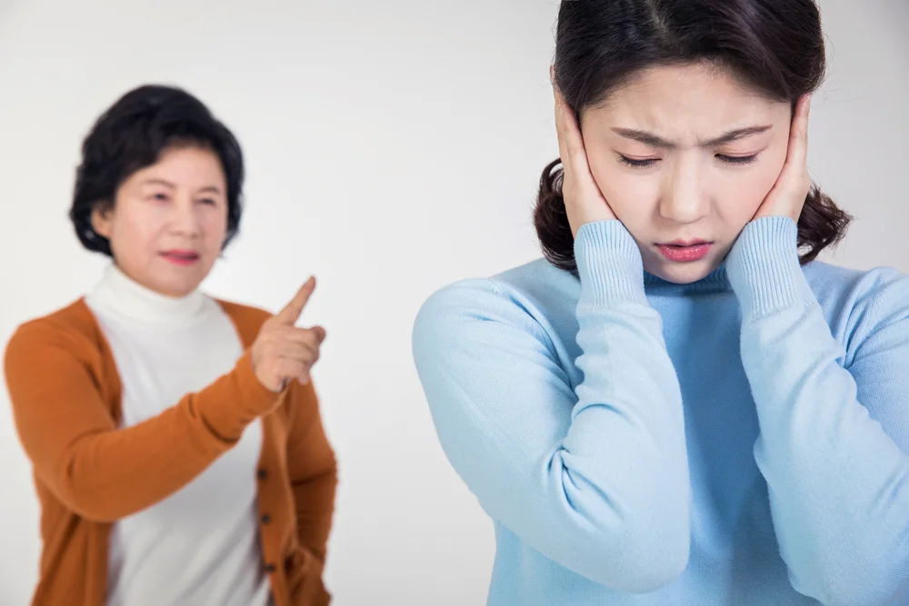 정신적 피해 위자료 액수 기준|시어머니의 잔소리에 귀를 막고 괴로워하는 여성의 모습