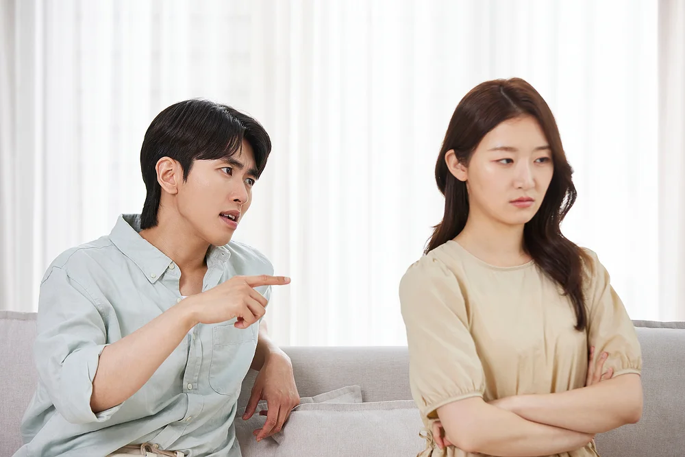 이혼 거부|거실 소파에서 서로 다투고 있는 남녀의 모습