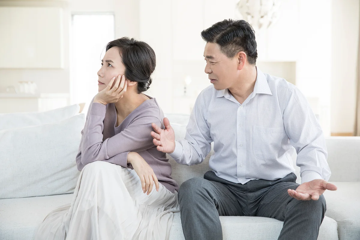 배우자 가출 이혼|거실 소파에 앉아 서로 외면하며 갈등을 겪는 중년 부부